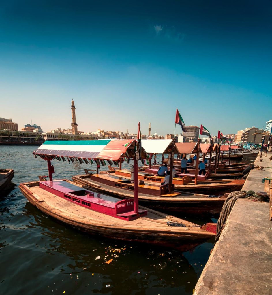 Traditional Abra taxi boats in Dubai creek - Deira during sunny day, Dubai Deira, United Arab Emirates SSUCv3H4sIAAAAAAAEAJ2SwW6DMAyG75P2DijnIkGAUfoq1Q4mCRA1JSgJnaqKd58DpfWu44S/P3Z+O358fiQJa8FrwU7JI0YYa2NmHxwEbUfE2eHJldTBOg0mwsiWVWE+QJi98qREzgvXYZzvuWDgeqeg1b0PVlymwQZLBakm63VYuadCh8BooMgPcwjKrYUiJ6YEBNWj2z+29k7PW5zswipiBkqMHQjzc7uyHS2Hf2duP9+vgfRqFHEij4W4dsoo2EZ53o6yyw92eF27eB66aaksiWGW2pIub1aAiQkFqTw5LfTYkzQbBuVILPDR7ZWA0YbVybMxJnGkMcyL/Kuu64rz8ljmGX5sXwR8By2p1203Bo2SuxOP82QsSCXfiG5NxQveNLyqXhN9LxBqRYa3FptEp6djOdZWdXnMqyKtMwFp2bVt2vBapE3HeQXA87ZU+CzLL6fKUN/9AgAA